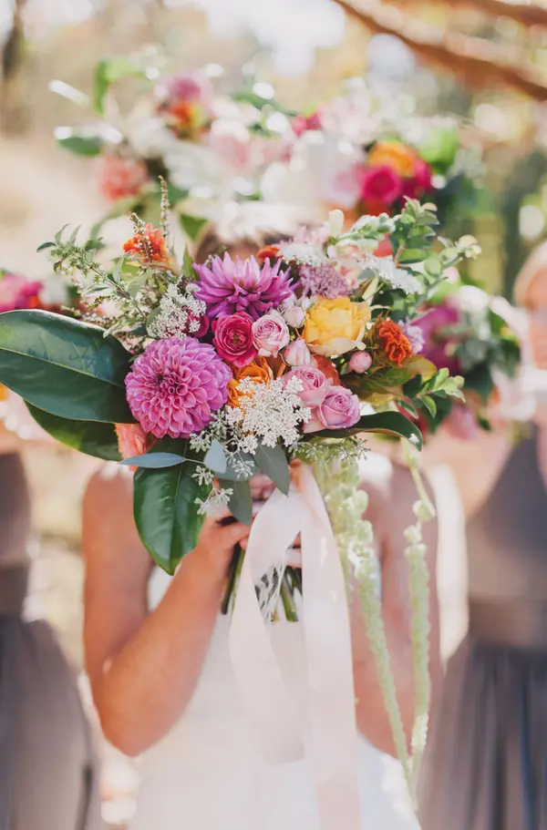 Colorful bridal bouquet with dahlias and roses at outdoor Pacific Northwest wedding. Lovely Events.