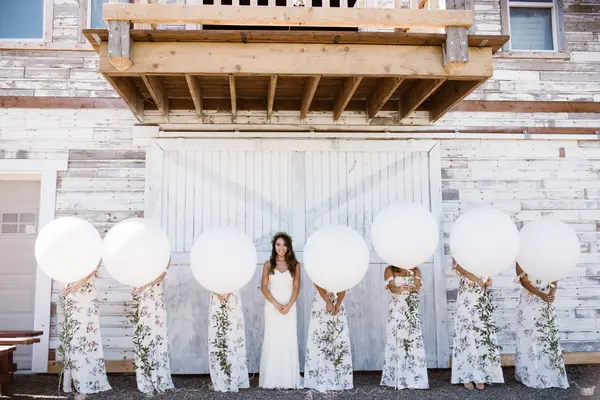 Bride and bridesmaids with balloons at rustic Washington wedding venue. Lovely Events.