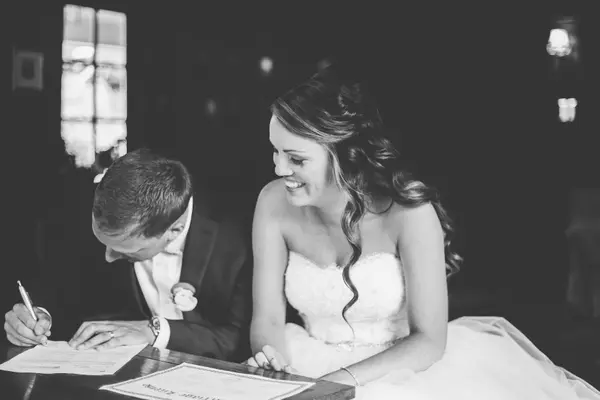 Bride and groom signing marriage certificate at Seattle-area wedding. Lovely Events.
