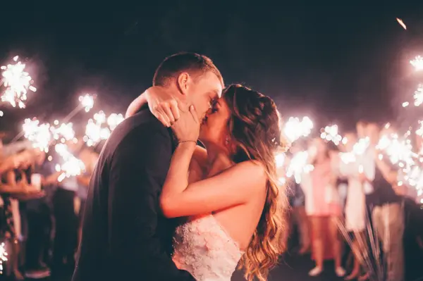 Bride and groom kissing with sparkler send-off at Pacific Northwest wedding. Lovely Events.